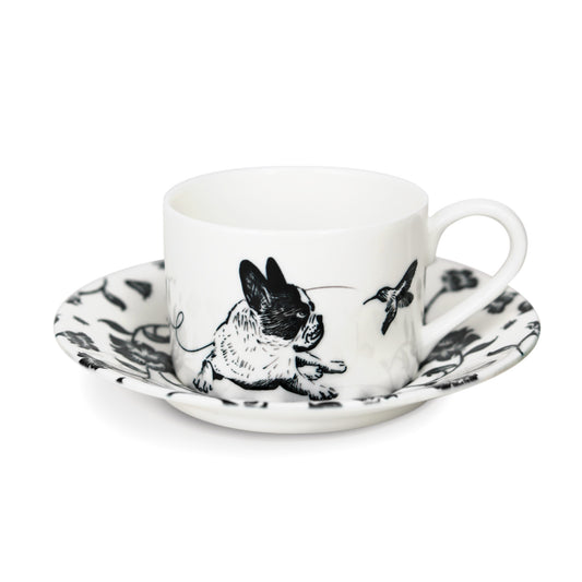 A black and white cup and saucer featuring a french bulldog design, elegantly displayed against a neutral background.