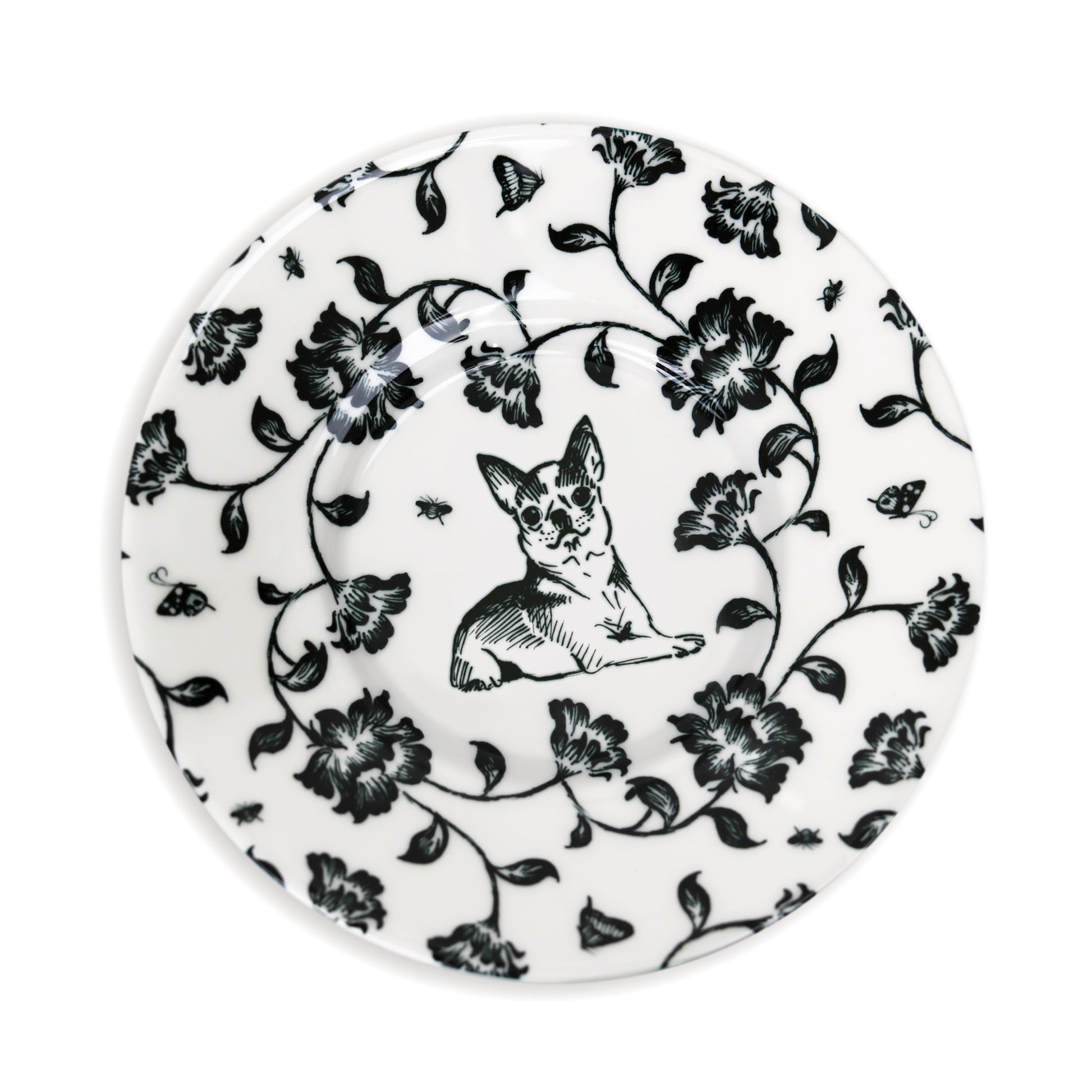 Close-up of black and white saucer design featuring dog and flower illustration.