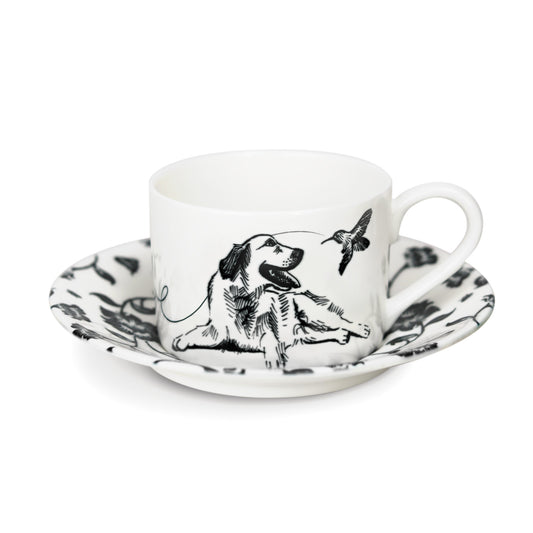 A black and white cup and saucer featuring a labrador retriever design, elegantly displayed against a neutral background.