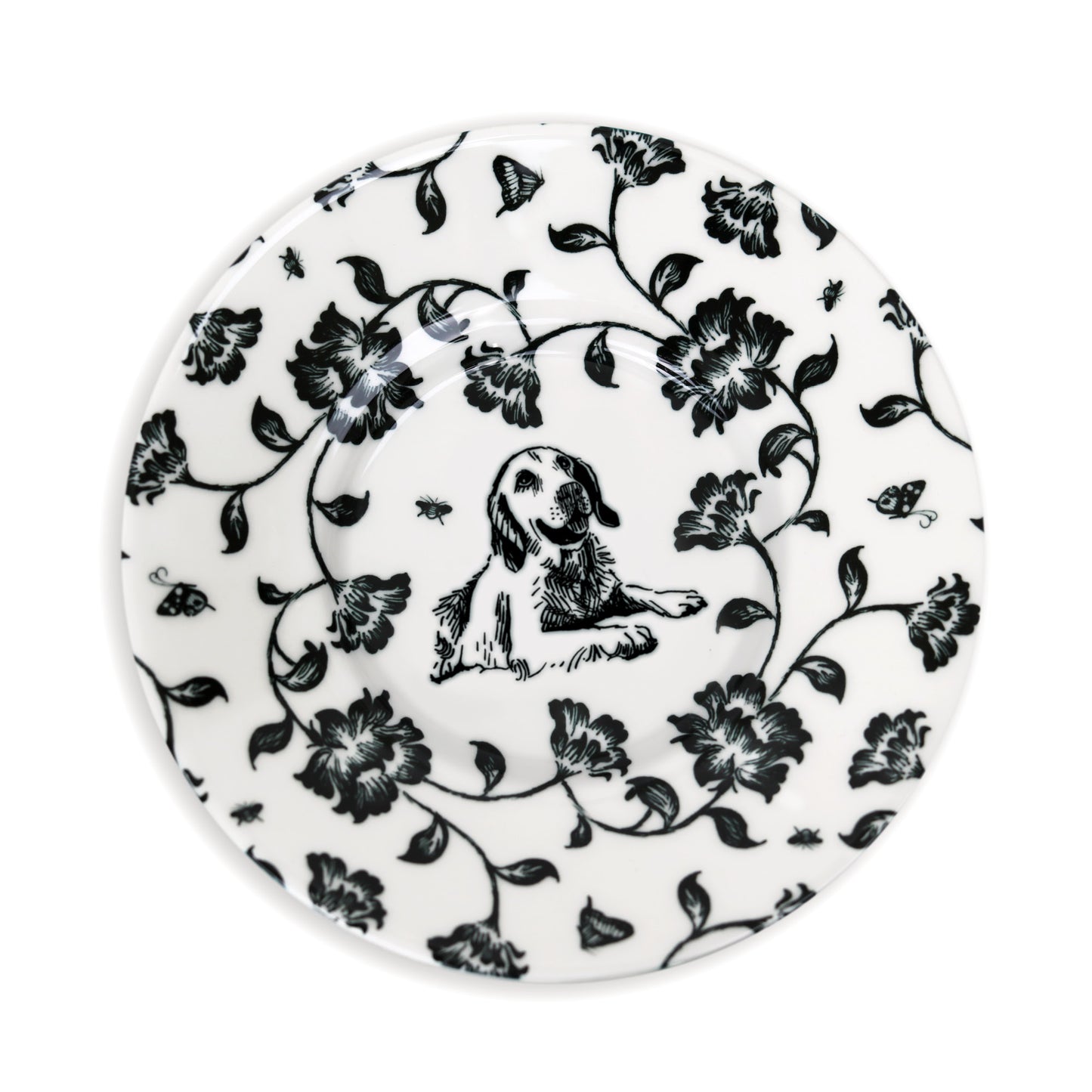 Close-up of black and white saucer design featuring dog and flower illustration.