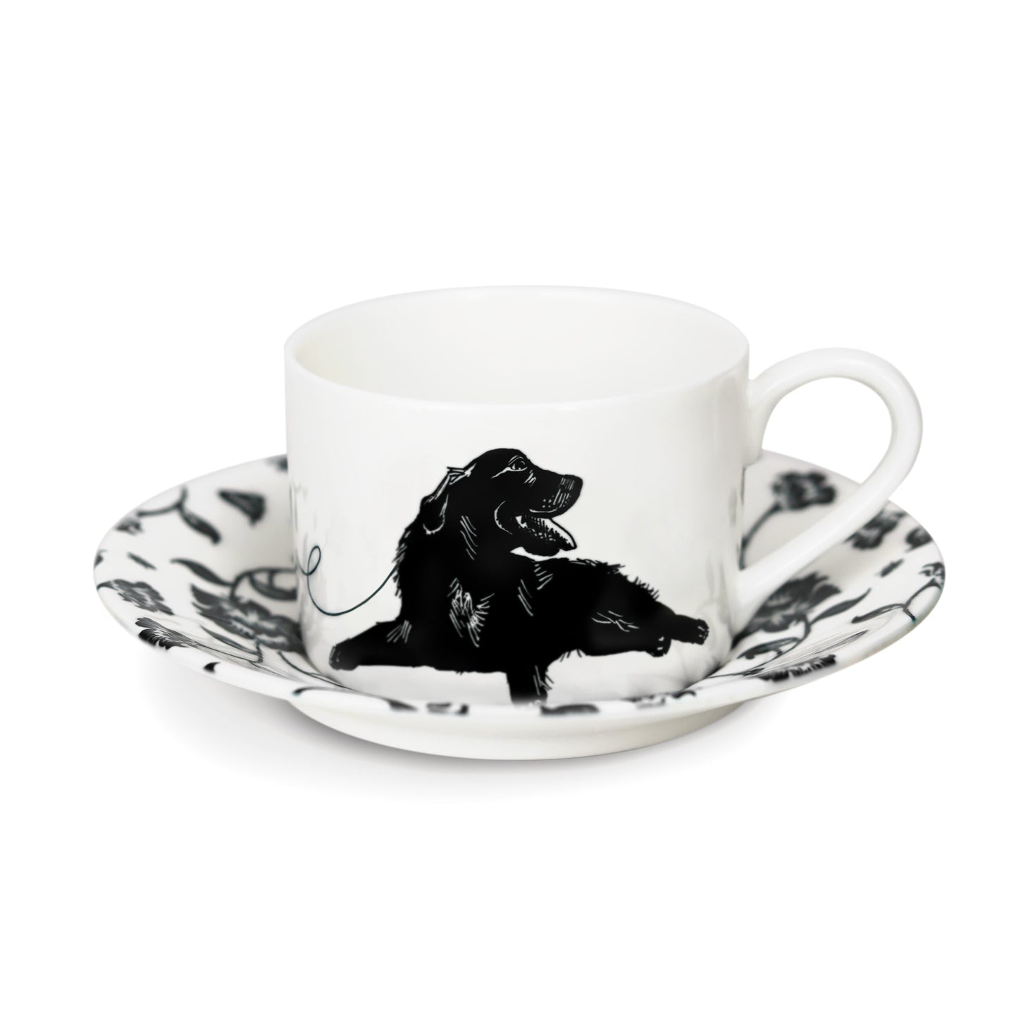 A black and white cup and saucer featuring a black labrador design, elegantly displayed against a neutral background.