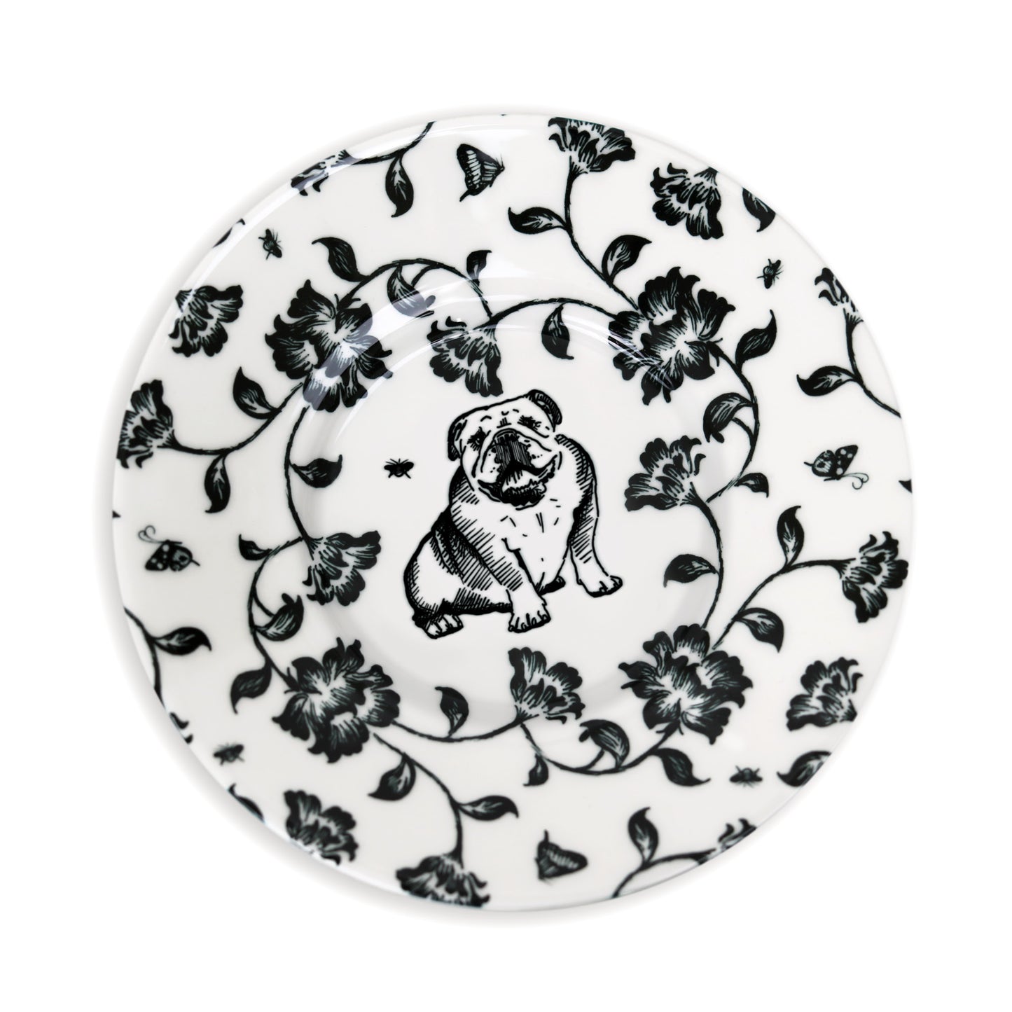 Close-up of black and white saucer design featuring dog and flower illustration.